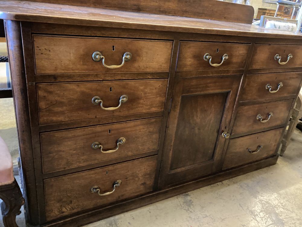A late George III mahogany low dresser, fitted nine small drawers, about a central cupboard, width 166cm, depth 58cm, height 102cm